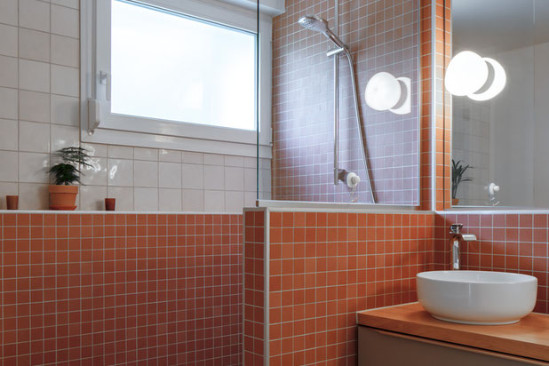 La salle de. bain lumineuse s'enveloppe d'un carrelage rouge pour mieux délimiter les espaces-renovation-appartement-Strasbourg