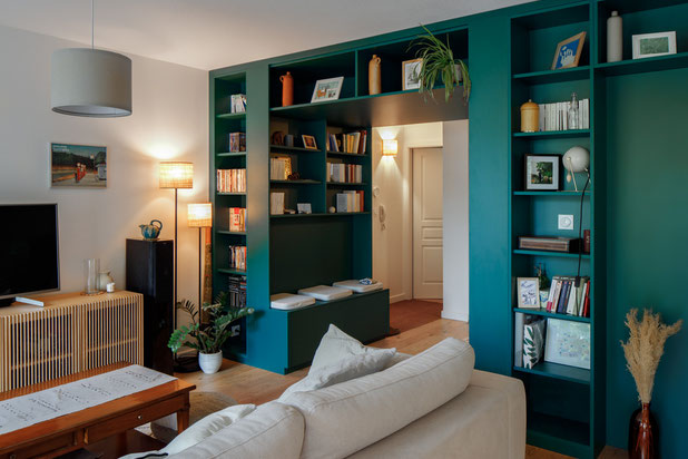 Une arche verte remplie de livres accueille les visiteurs dès l'entrée-renovation-appartement-Strasbourg