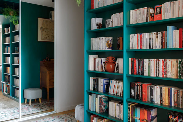 Une arche verte remplie de livres accueille les visiteurs dès l'entrée-renovation-appartement-Strasbourg