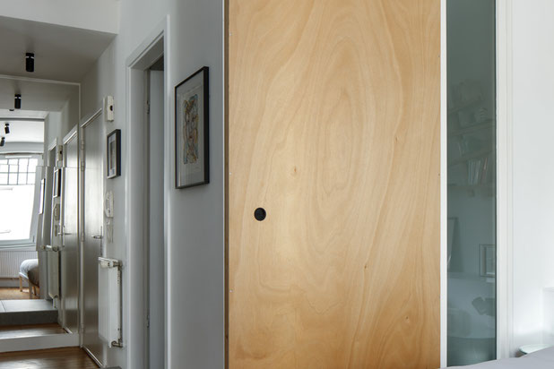 Dans l'entrée, un miroir prolonge la perspective tandis qu'une large porte coulissante permet d'isoler la chambre-renovation-appartement-Schiltigheim