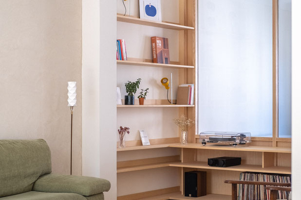 La paroi vitrée en frêne se retourne avec des étagères dans le creux du poteau-rehabilitation-appartement-Strasbourg