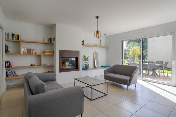 Espace salon avec étagères bois et banquette autour de la cheminée-amenagement-maison-Muzillac