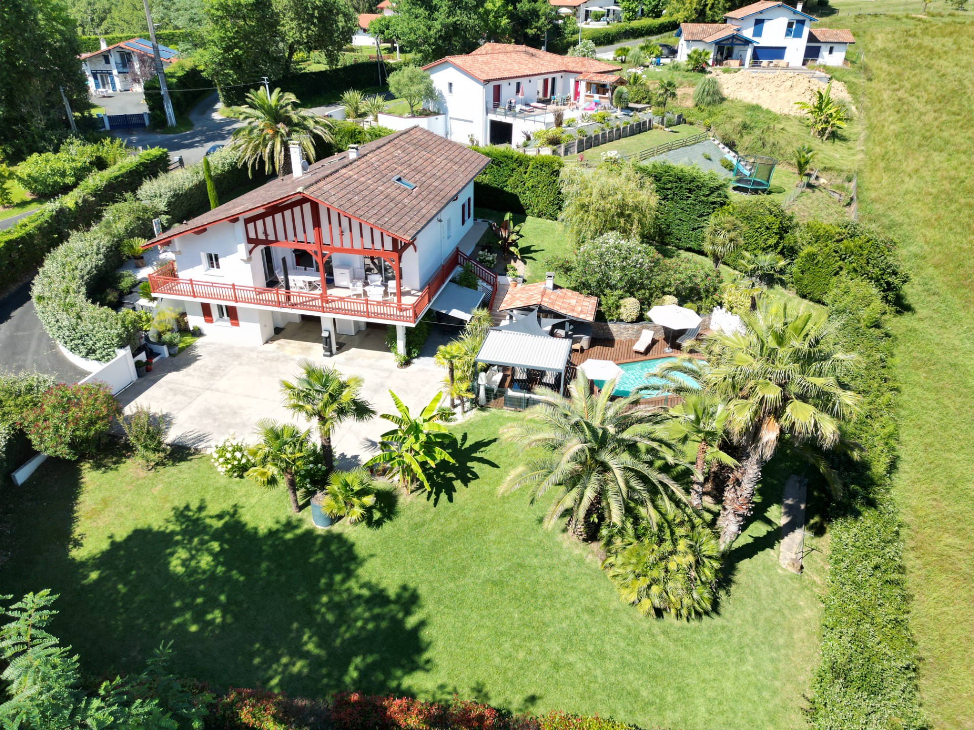 Une maison familiale ensoleillée avec piscine entourée de bois, au calme absolu