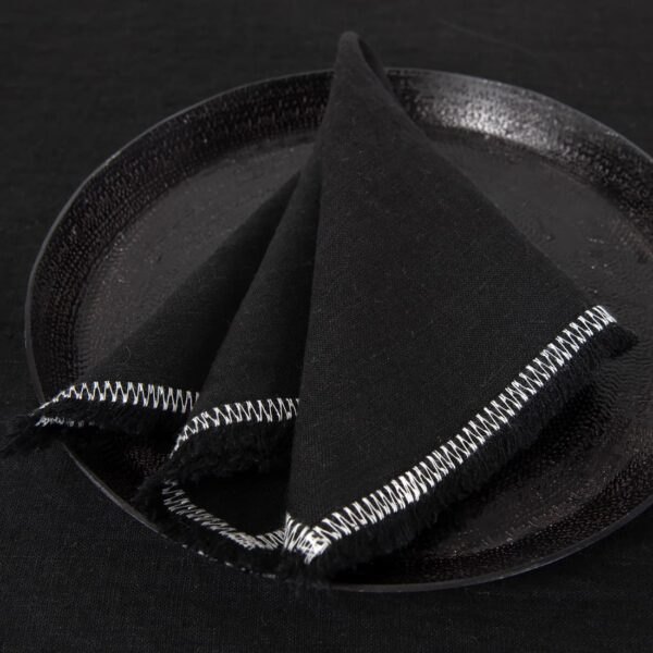 black linen napkin with decorative stitch.