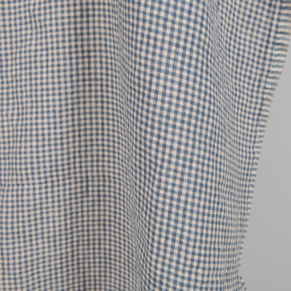 Washed linen fabric with small blue and brownish checks close edge view