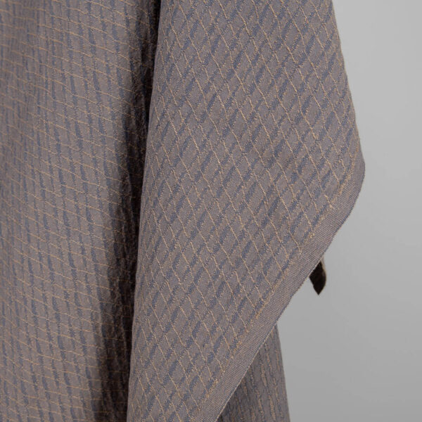 Washed linen cotton fabric blueish grey and brown pattern close up edge view