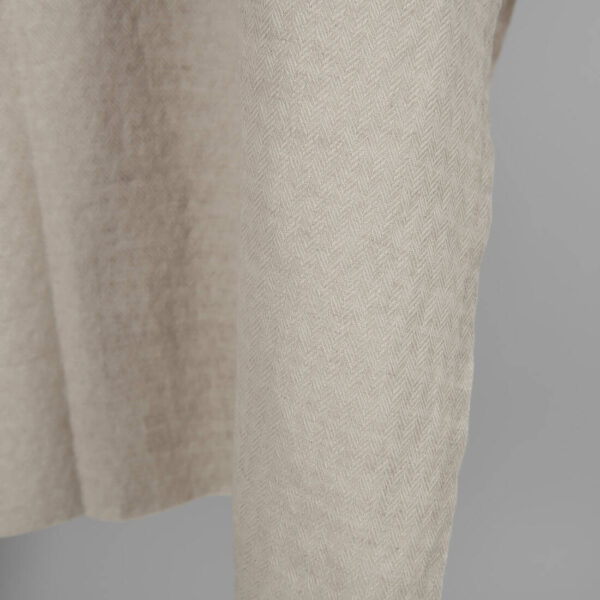 Washed linen cotton sand colour herringbone pattern close up edge view