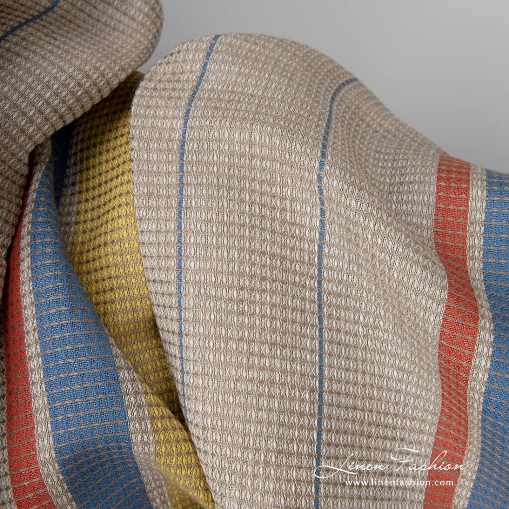 Tissu de lin et de coton gaufré sable avec rayures jaunes et rouges 3 Linen cotton fabric sand waffle with yellow red stripes close up detail