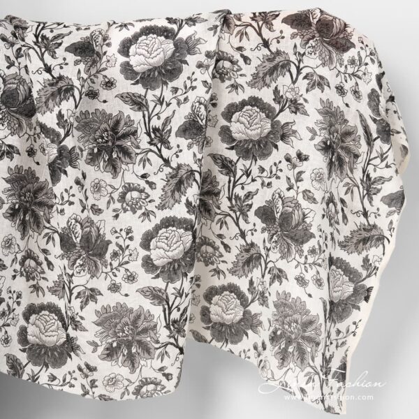 Gauzy linen fabric with black printed flowers.