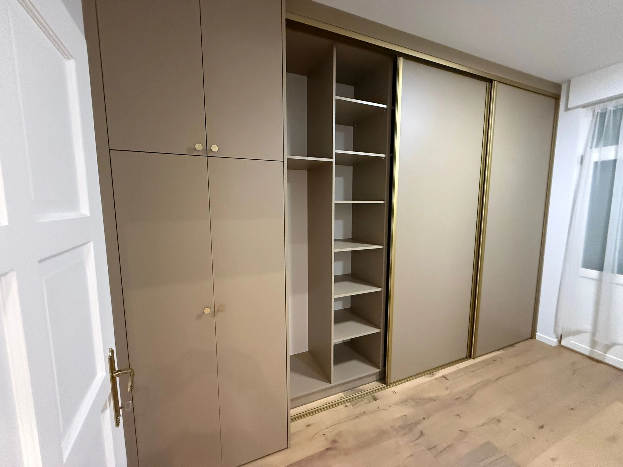 Taupekleurige schuifkast op maat met goudkleurige profielen