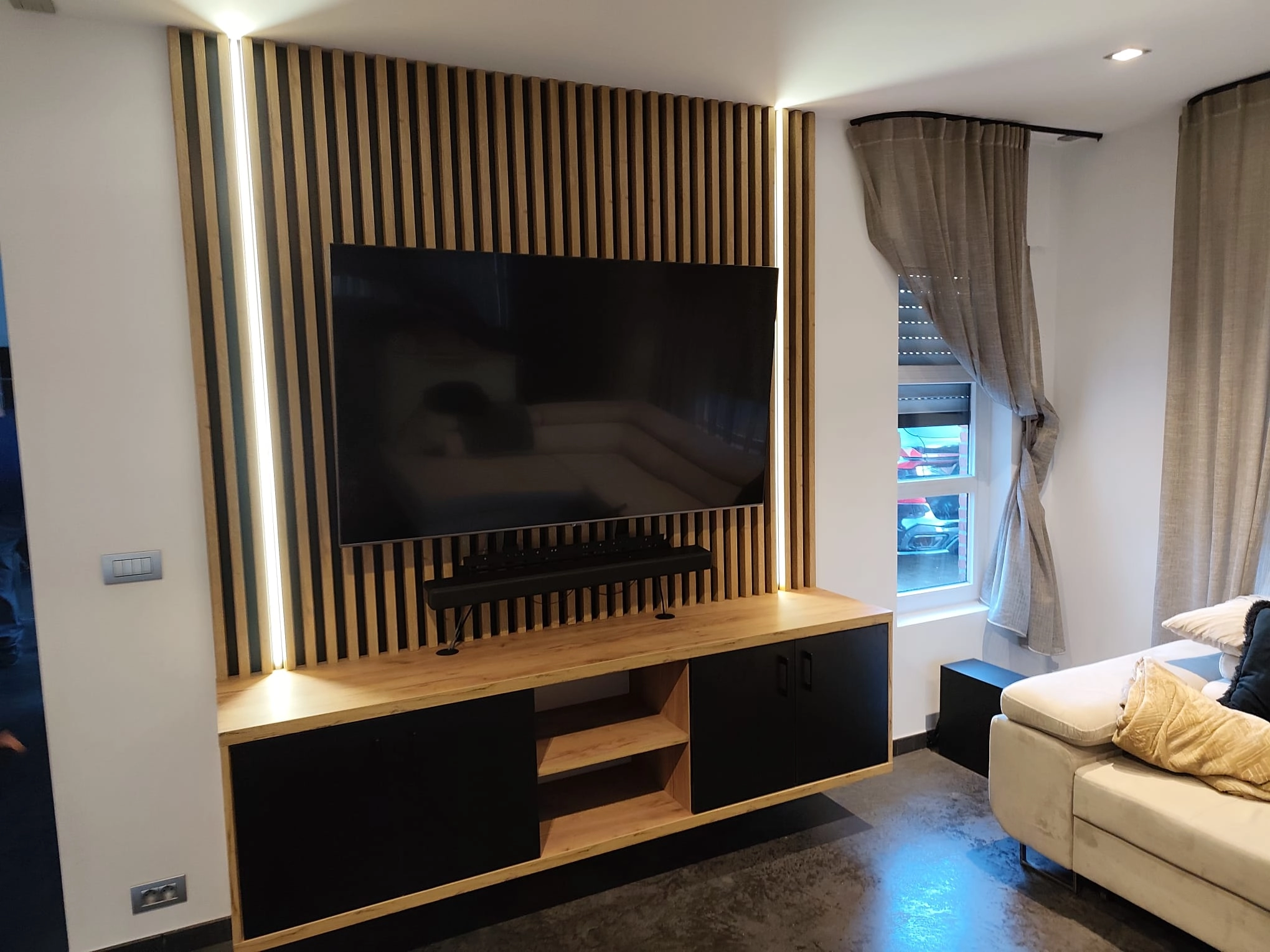 TV-meubel op maat met houten lattenwand en verlichting