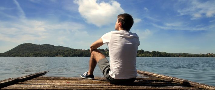 Bateau stop : jeune homme assis sur un quai
