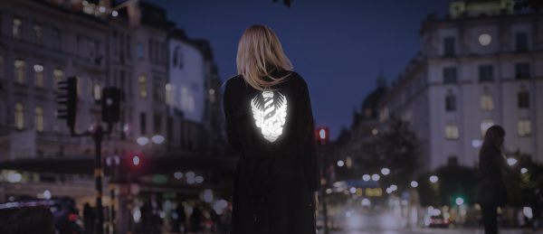 Rear view of woman walking on city street at night