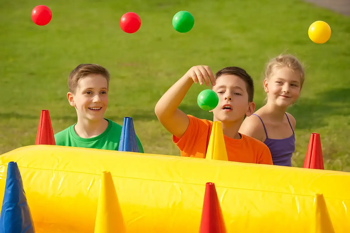 trois enfants joue au airball avec des balles qui flottent