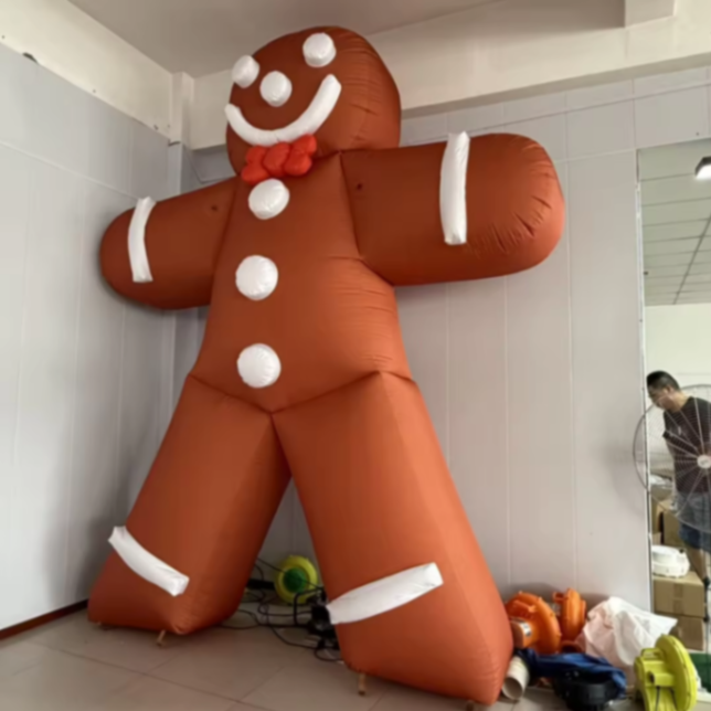 bonhomme pain d'épice gonflable marron et blanc avec un nœud papillon rouge