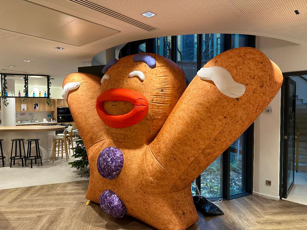 Bonhomme Pain d’épice Joyeux Gonflable avec deux boutons violet et qui sourit  vue de  profil 