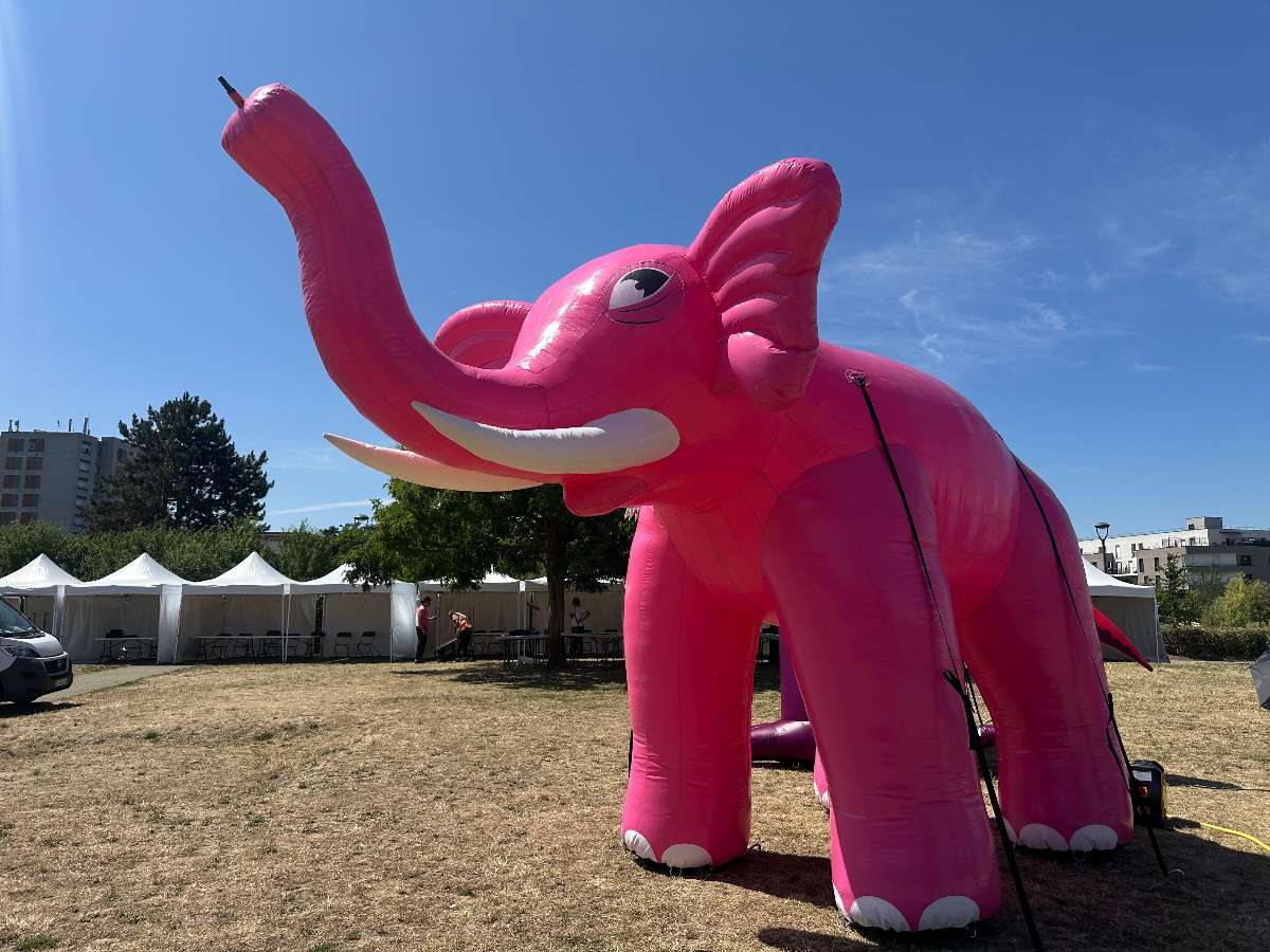 un éléphant Rose Gonflable brumisateur qui projette de l'eau par sa trompe avec ses défenses