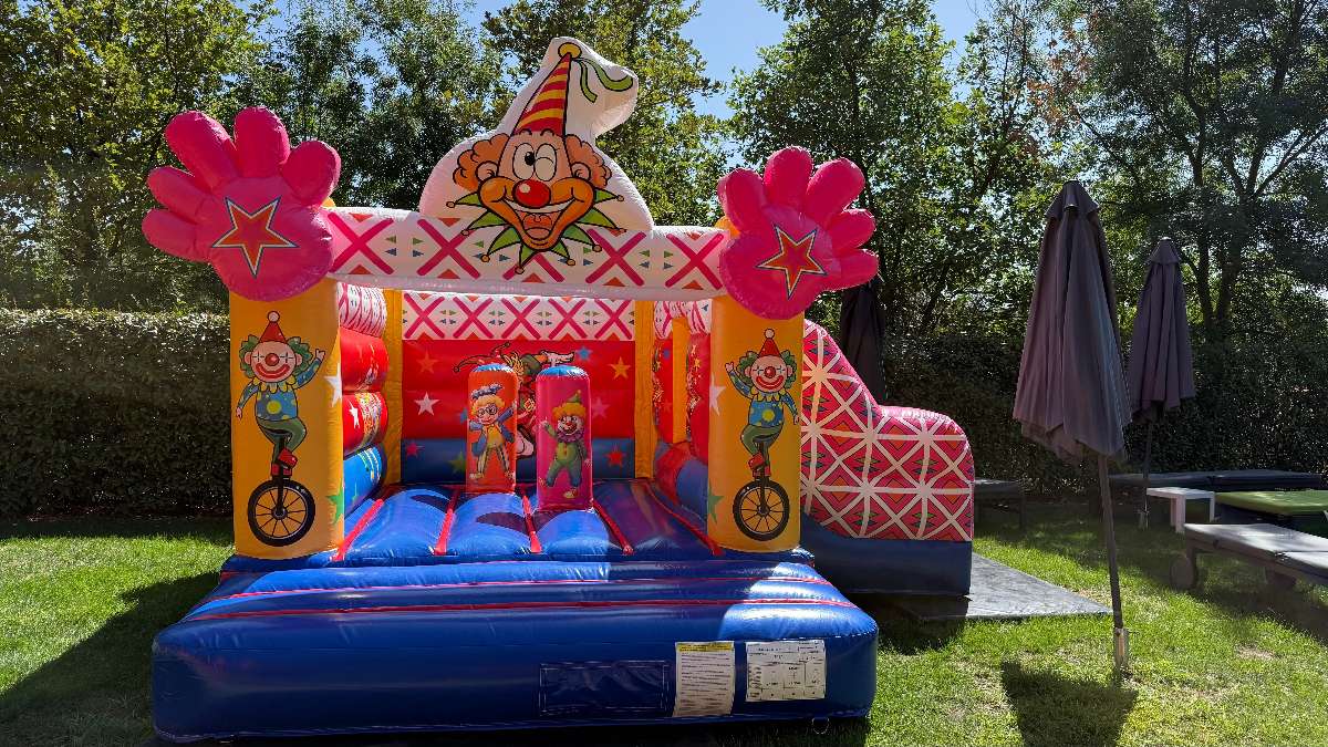 Château cirque avec un clown en hauteur et des mains roses vue de face 