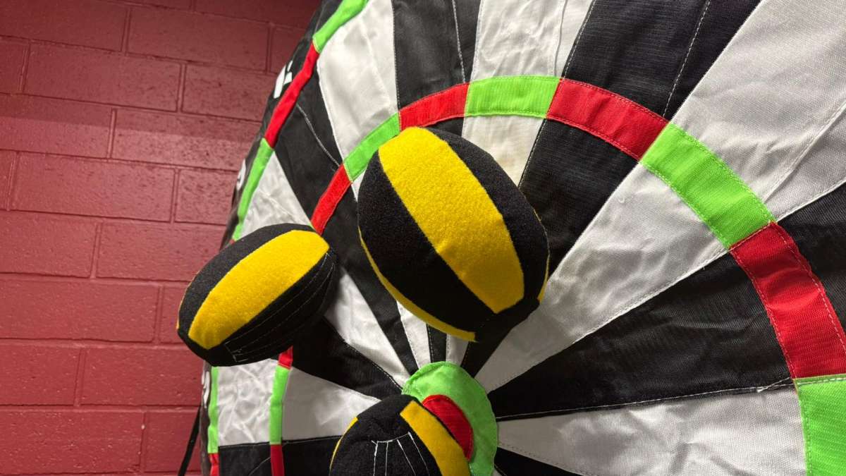 3 balles Velcros rugby jaune et noir qui sont accroché sur la cible