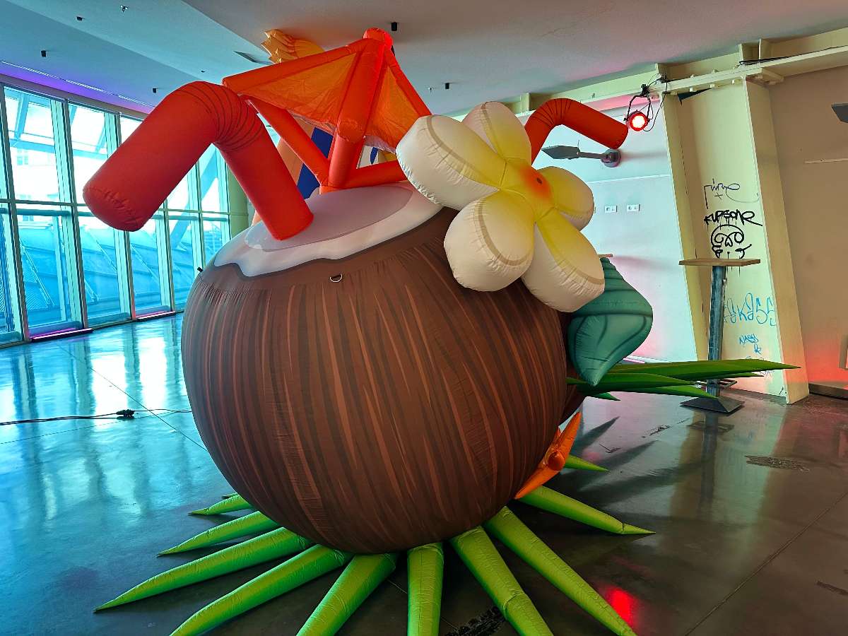 Noix de coco gonflable avec une fleur blanche et jaune et des pailles orange 