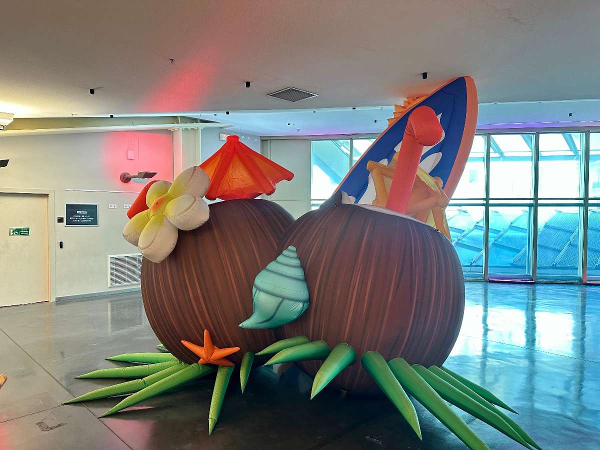 Noix de coco gonflable avec une fleur blanche et jaune et des pailles orange 