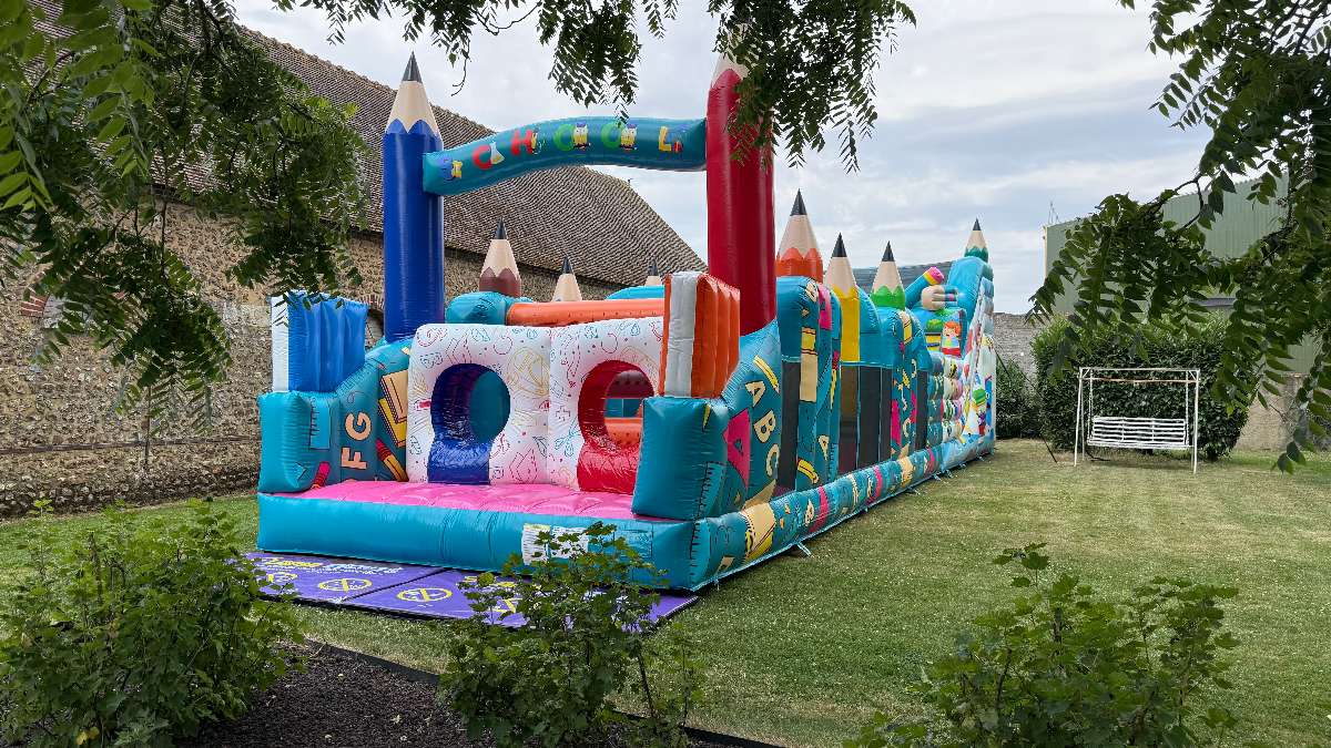 parcours gonflables écolier avec des crayons énormes a l'entrée structure coloré en bleu ciel et multicolore et ludique