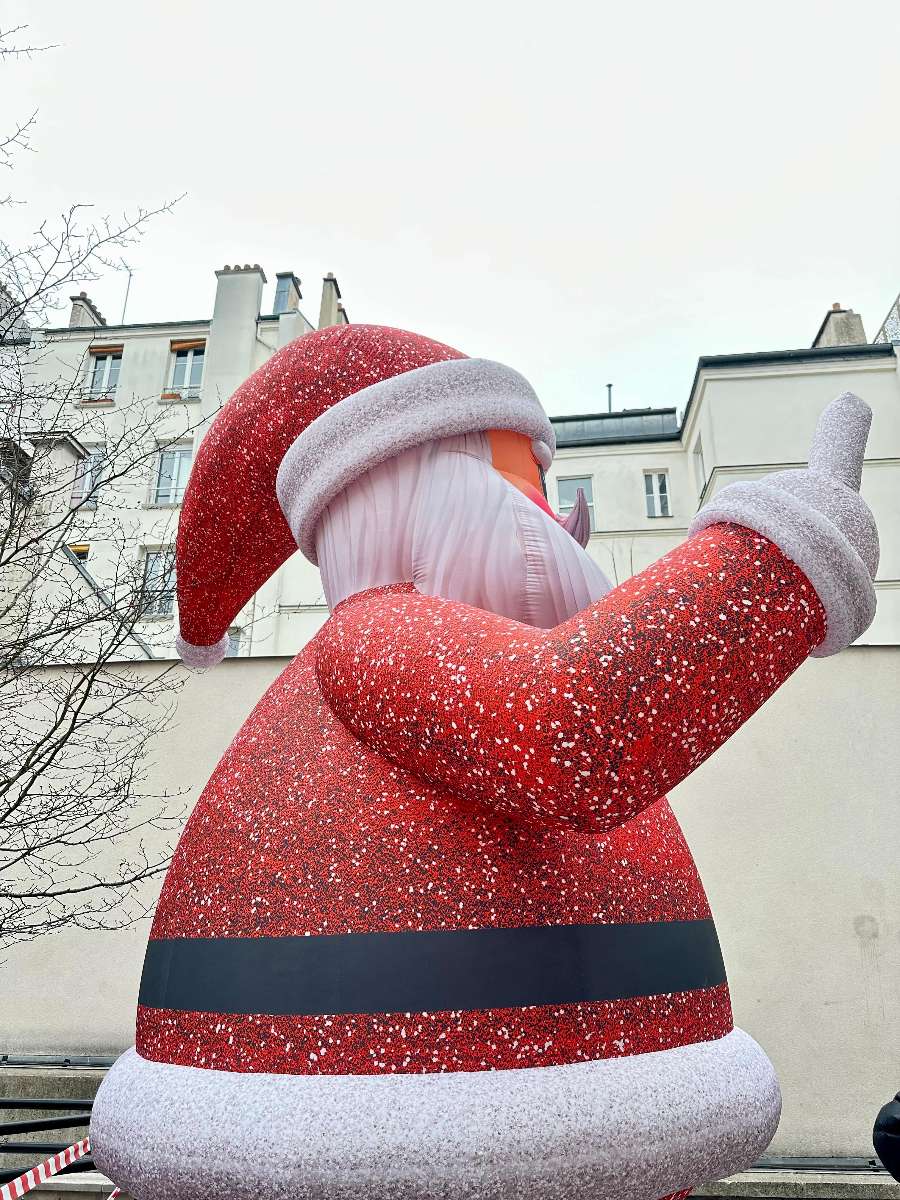 Père Noël Géant Gonflable avec un sucre d'orge dans la main gauche vue de profil