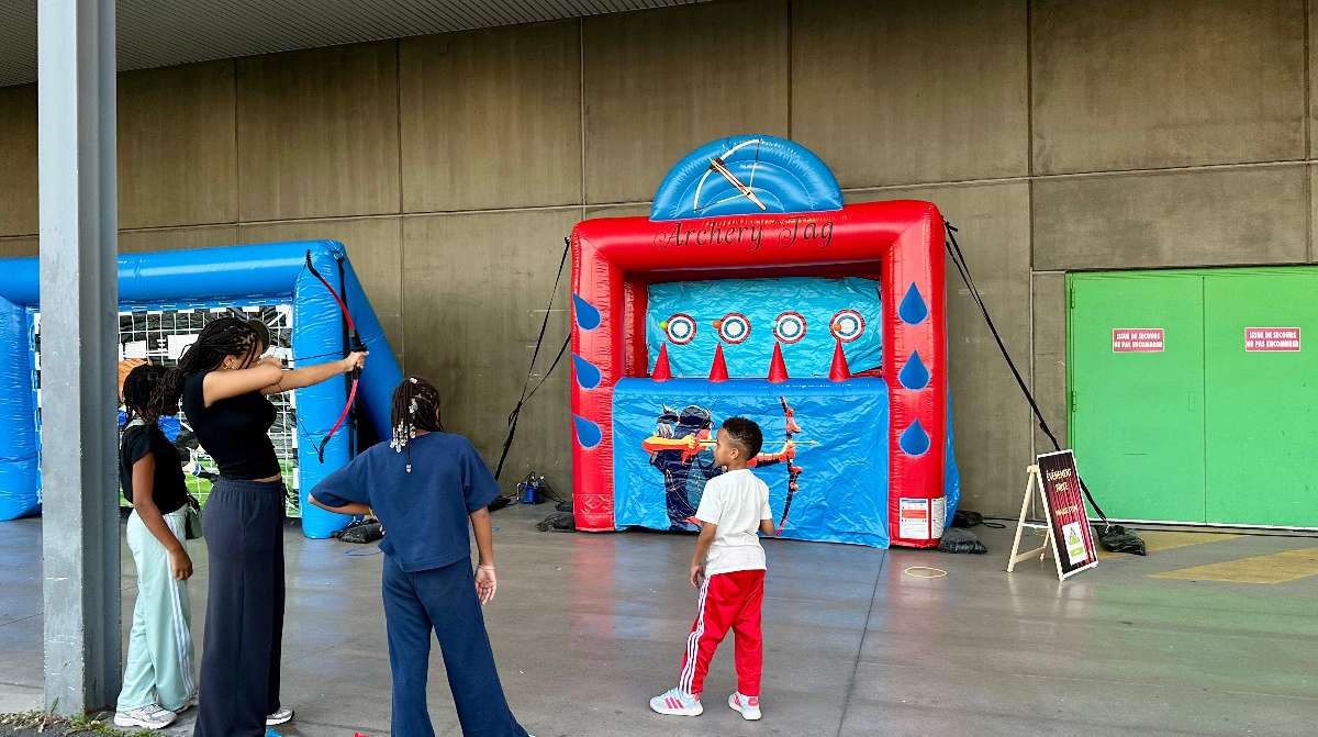 des enfants tirent a l'arc pour viser les balles flottante 