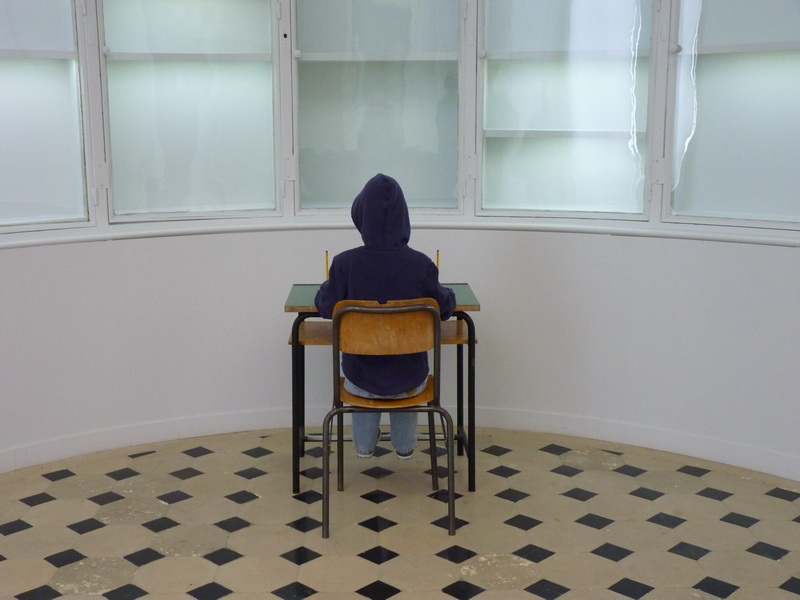 p1570733-maurizio-cattelan-charlie-don-t-surf-112x71x70cm-1997-mannequin-table-et-chaise-d-ecole-vetements-peinture-chaussures-crayons
