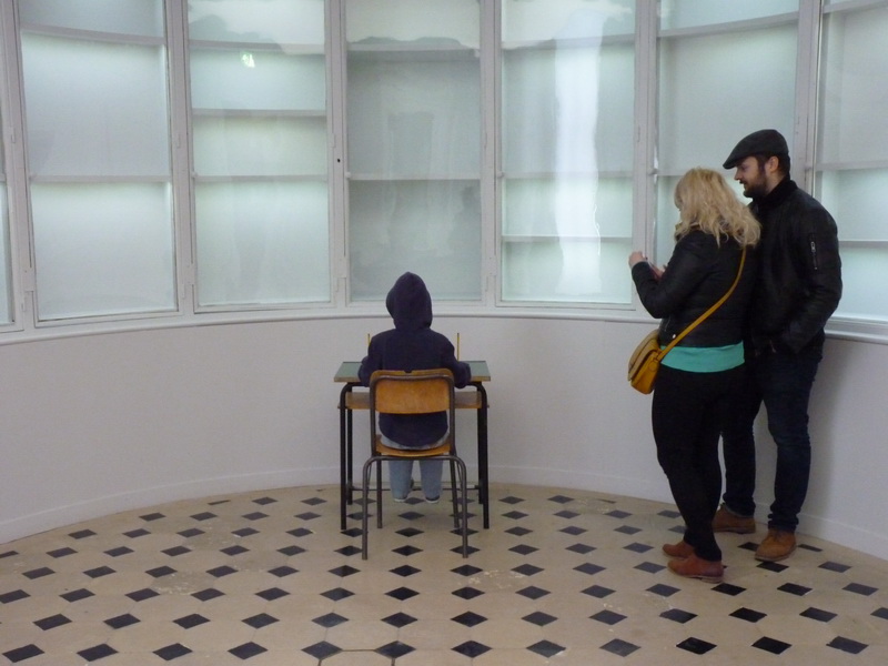 p1570743-maurizio-cattelan-charlie-don-t-surf-112x71x70cm-1997-mannequin-table-et-chaise-d-ecole-vetements-peinture-chaussures-crayons